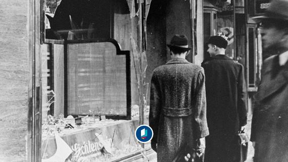 People passing a broken window of a Jewish shop, November 1938