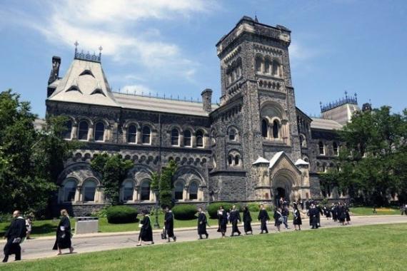 students walk by a building of the University of Toronto