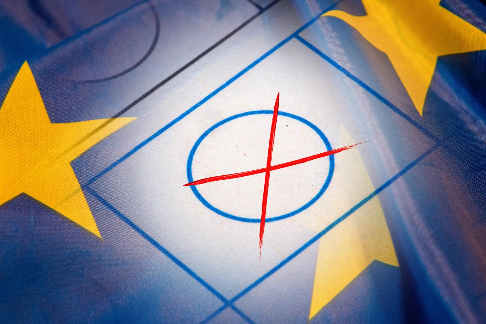 Nahaufnahme eines Wahlkreuzes vor dem Wappen der Europäischen Union