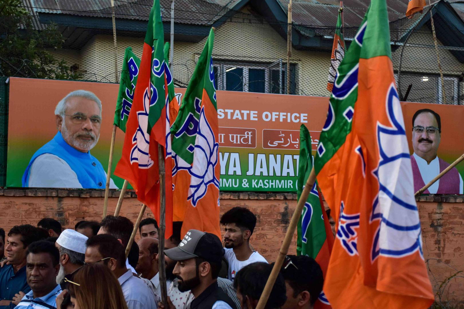 Anhänger der Bharatiya Janata Party (BJP) halten Parteifahnen, während sie Narendra Modis Vereidigung als Premierminister für die dritte Amtszeit in Folge in Srinagar feiern.