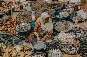 A woman selling her goods in an open air market.