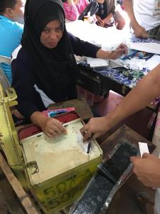 Member of Board of Election Inspection witnessing a voter casting his vote.