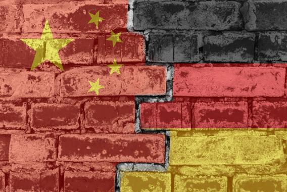 Chinesische und Deutsche Flagge vor einer geziegelten Mauer